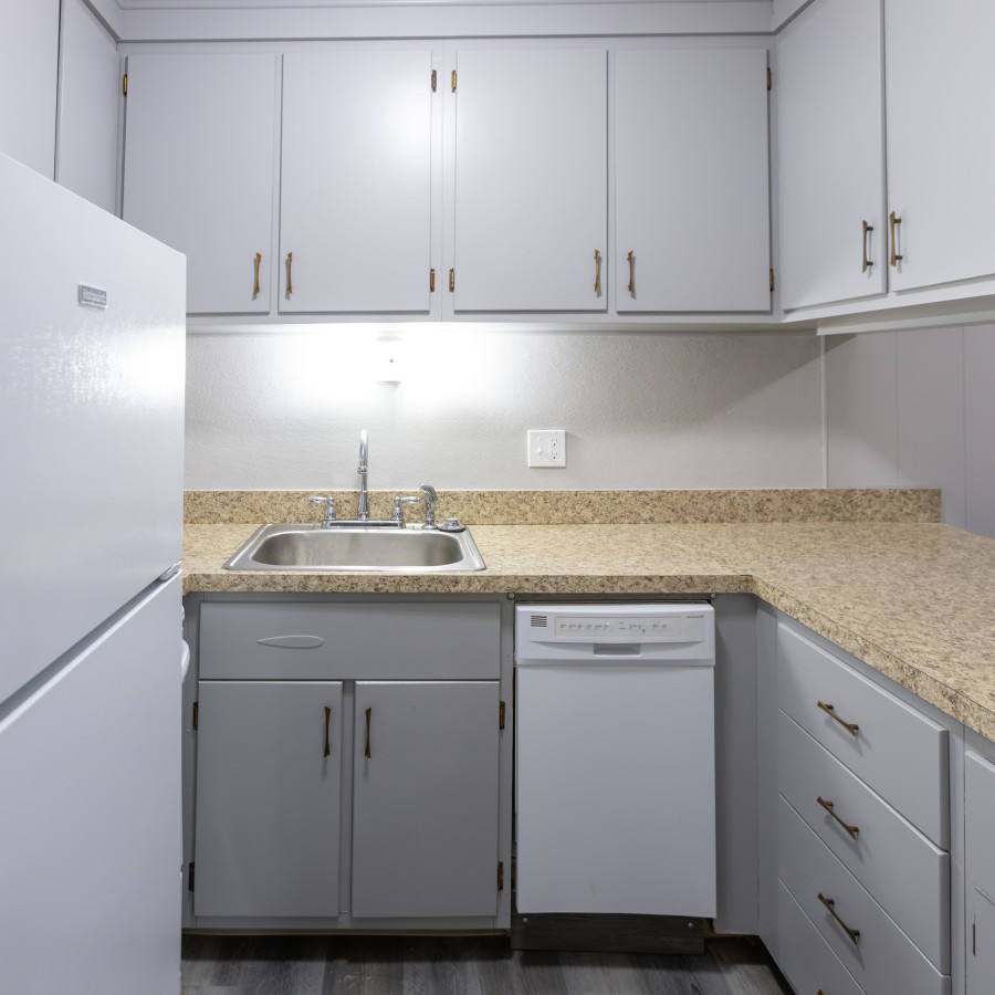 Kitchen with granite-look counters, dishwasher and refrigerator at Carriage House Apartments, Syracuse NY