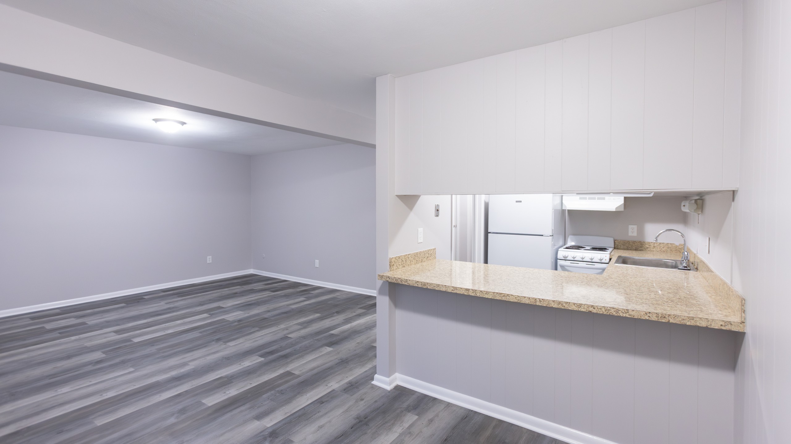 One-bedroom living area with granite breakfast counter at Carriage House Apartments, Syracuse NY