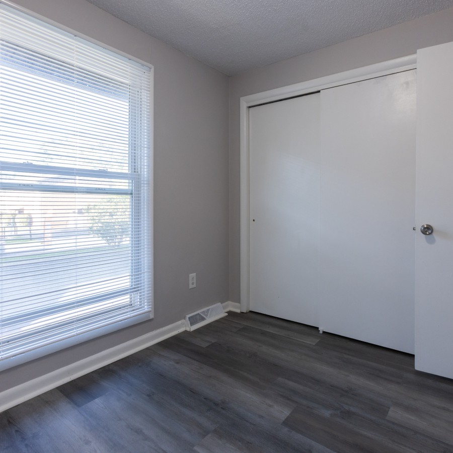 Two-bedroom bedroom with a large window and double closet at Carriage House Apartments, Syracuse NY