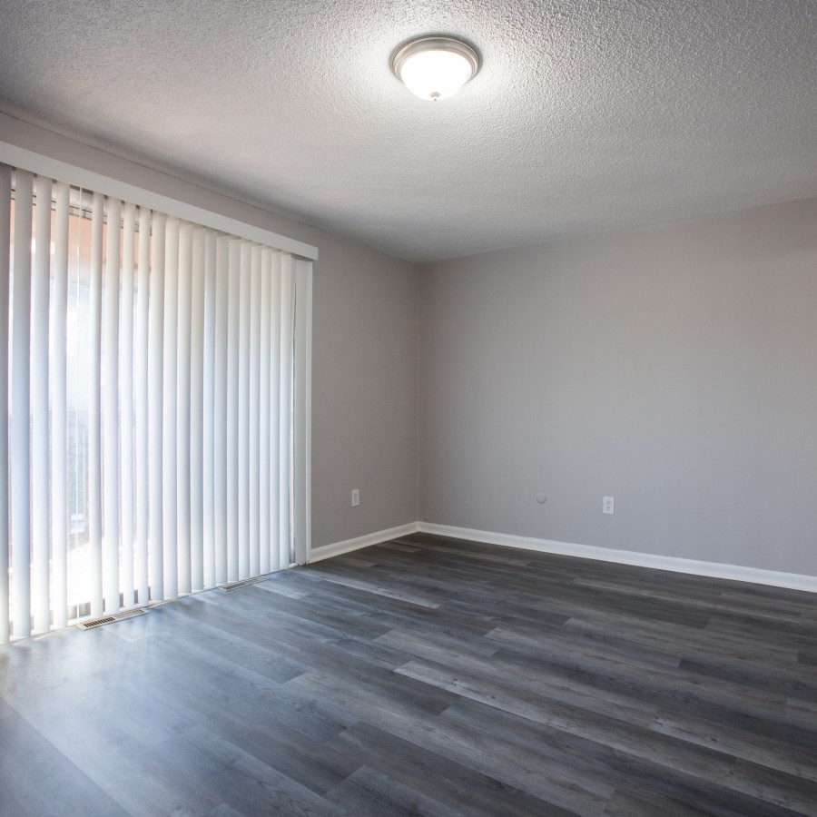 Two-bedroom living room with a sliding glass door at Carriage House Apartments, Syracuse NY