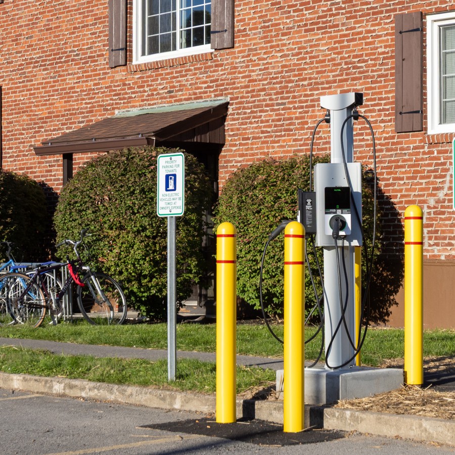 Electric vehicle charging station by a building entrance at Carriage House Apartments, Syracuse NY