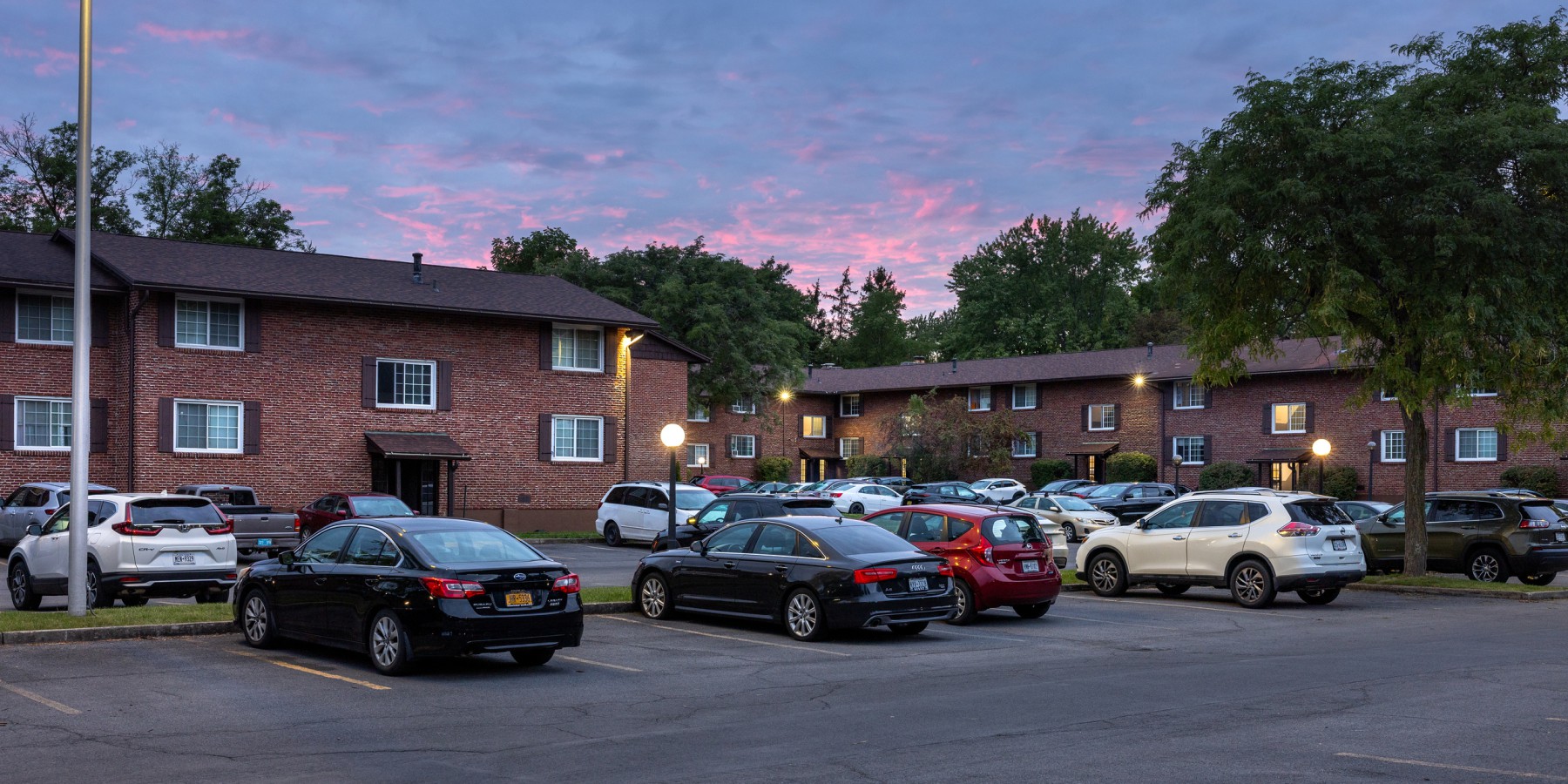 Buildings and parking lot at dusk at Carriage House Apartments, Syracuse NY